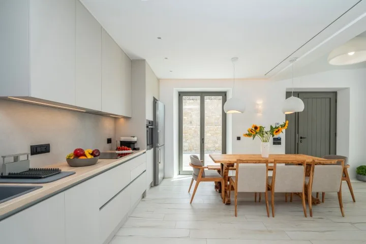 A bright kitchen and dining area with a long wooden table.