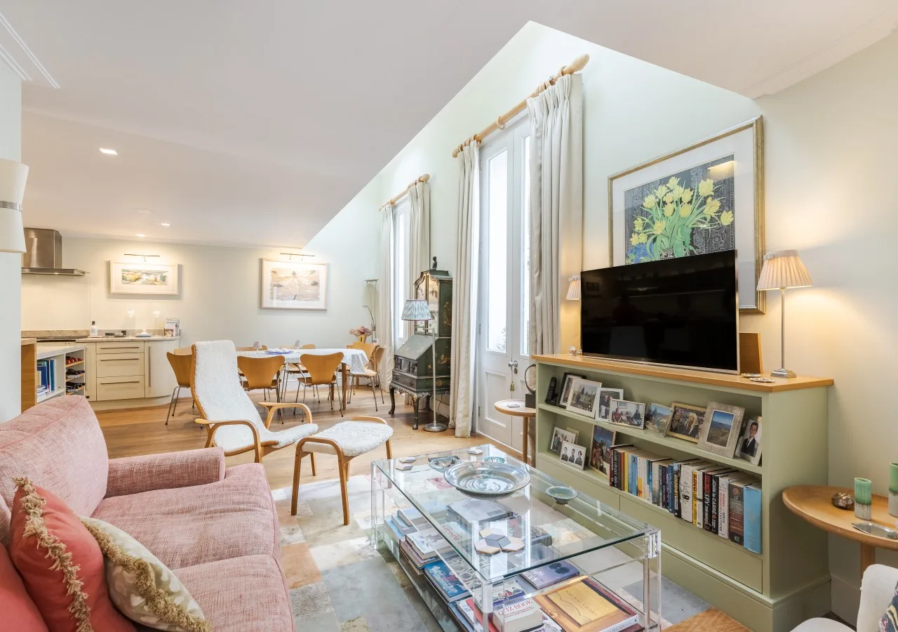A bright living and dining area with a television, seating, and a dining table.