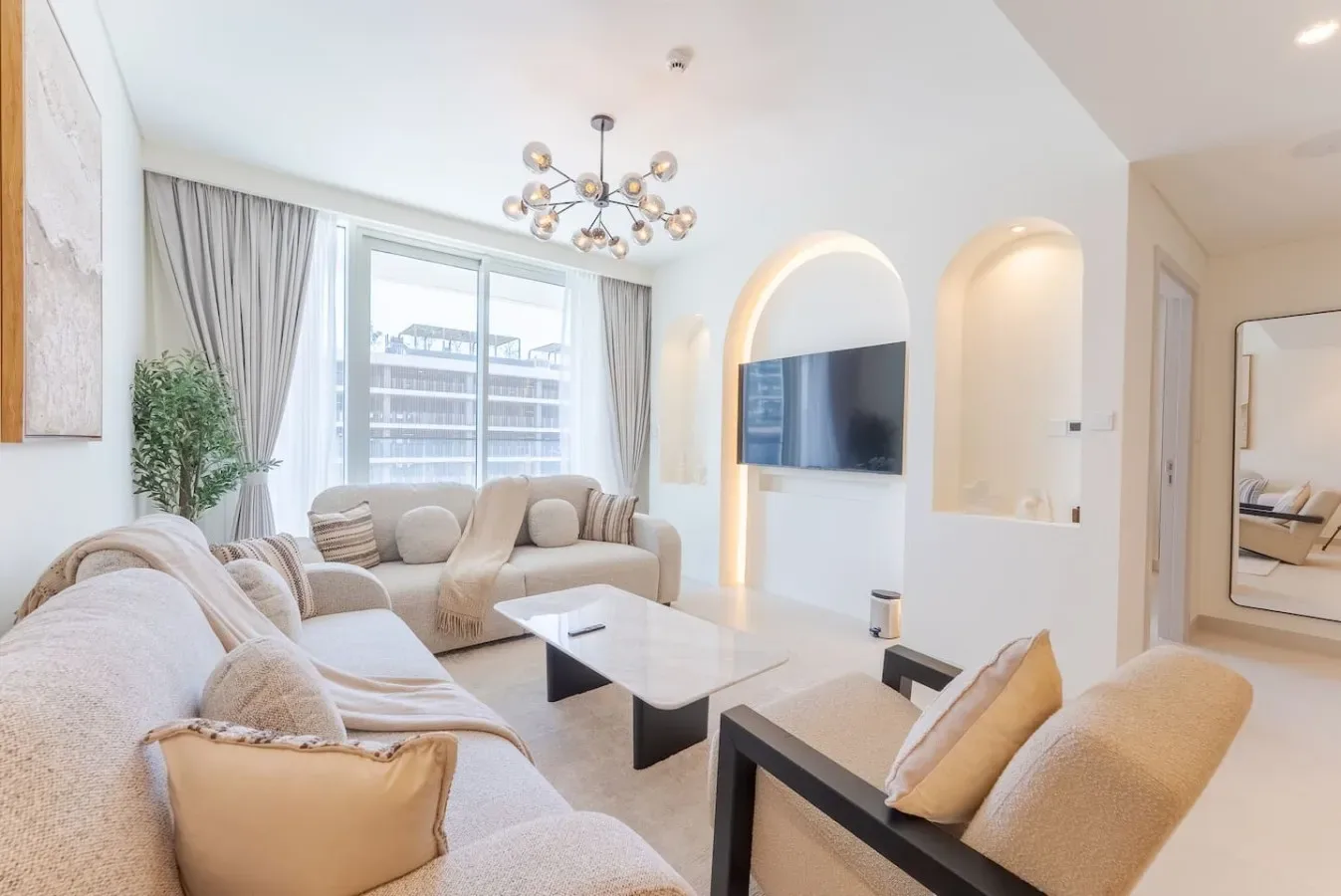 Una sala luminosa con asientos, una mesa de centro y un televisor.