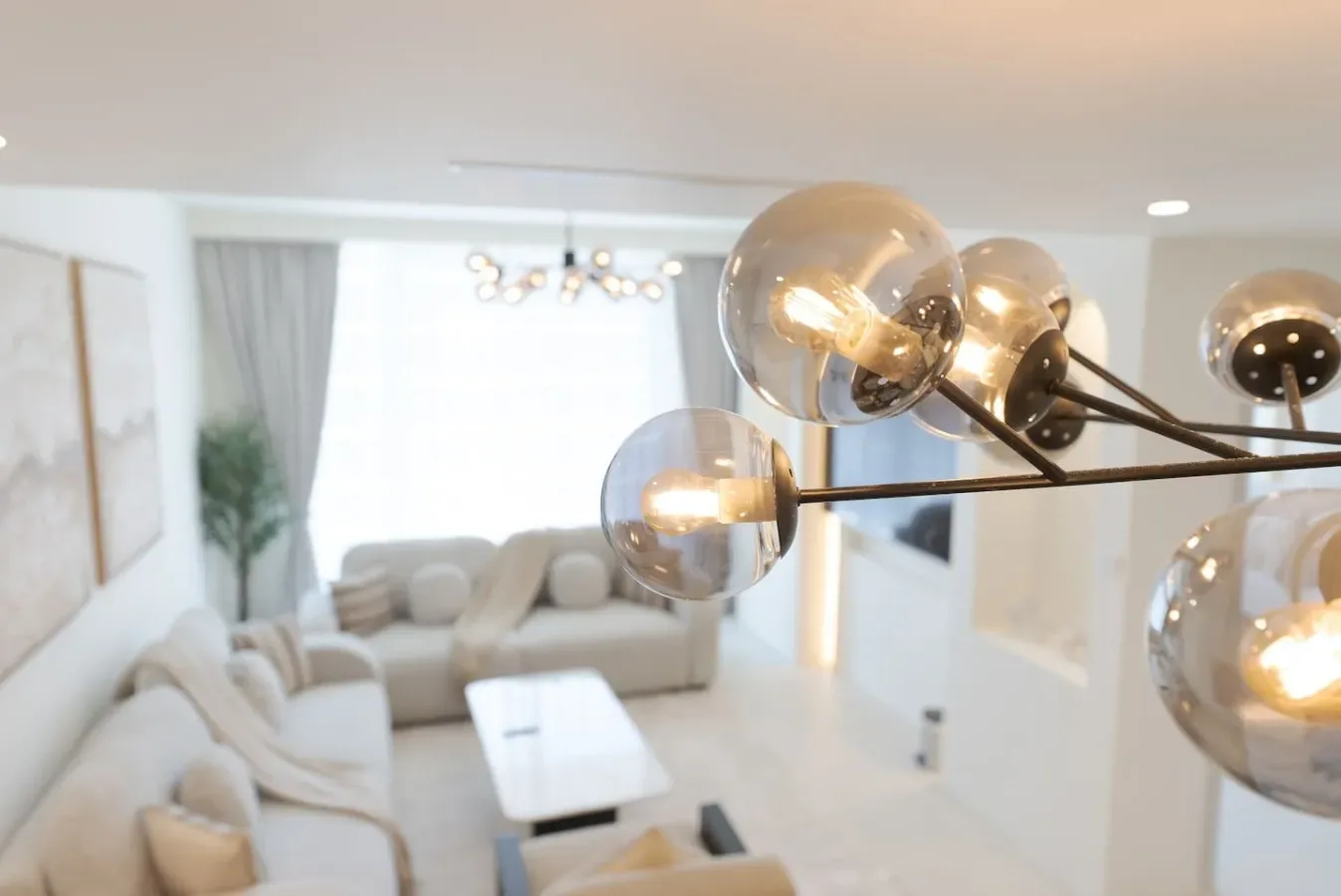 Una sala luminosa con asientos claros y una mesa de centro de vidrio.