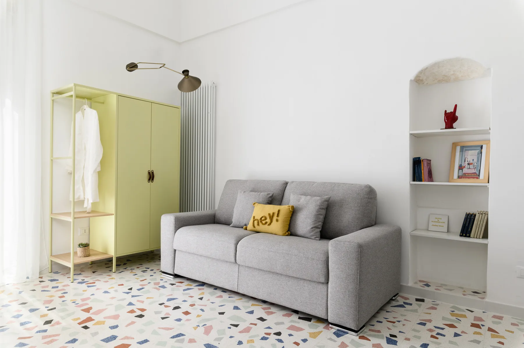 A bright sitting room with gray seating and built-in shelves.