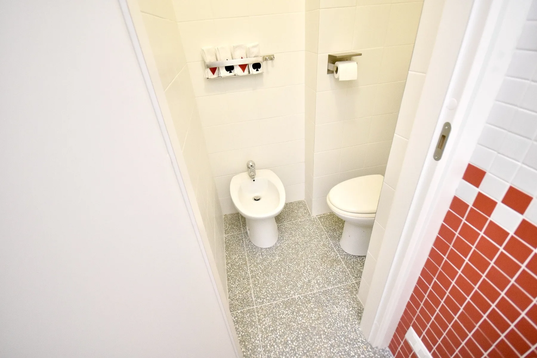 A tiled bathroom with a toilet and bidet.