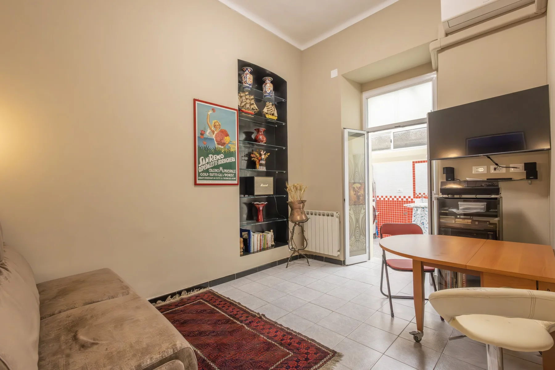 A living room with seating, a dining table, and a television.