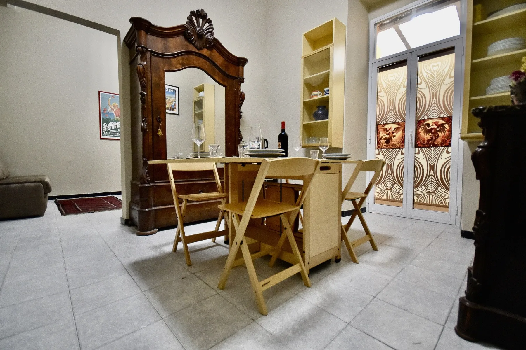 A dining area with a wooden table and folding chairs beside a tall mirror.