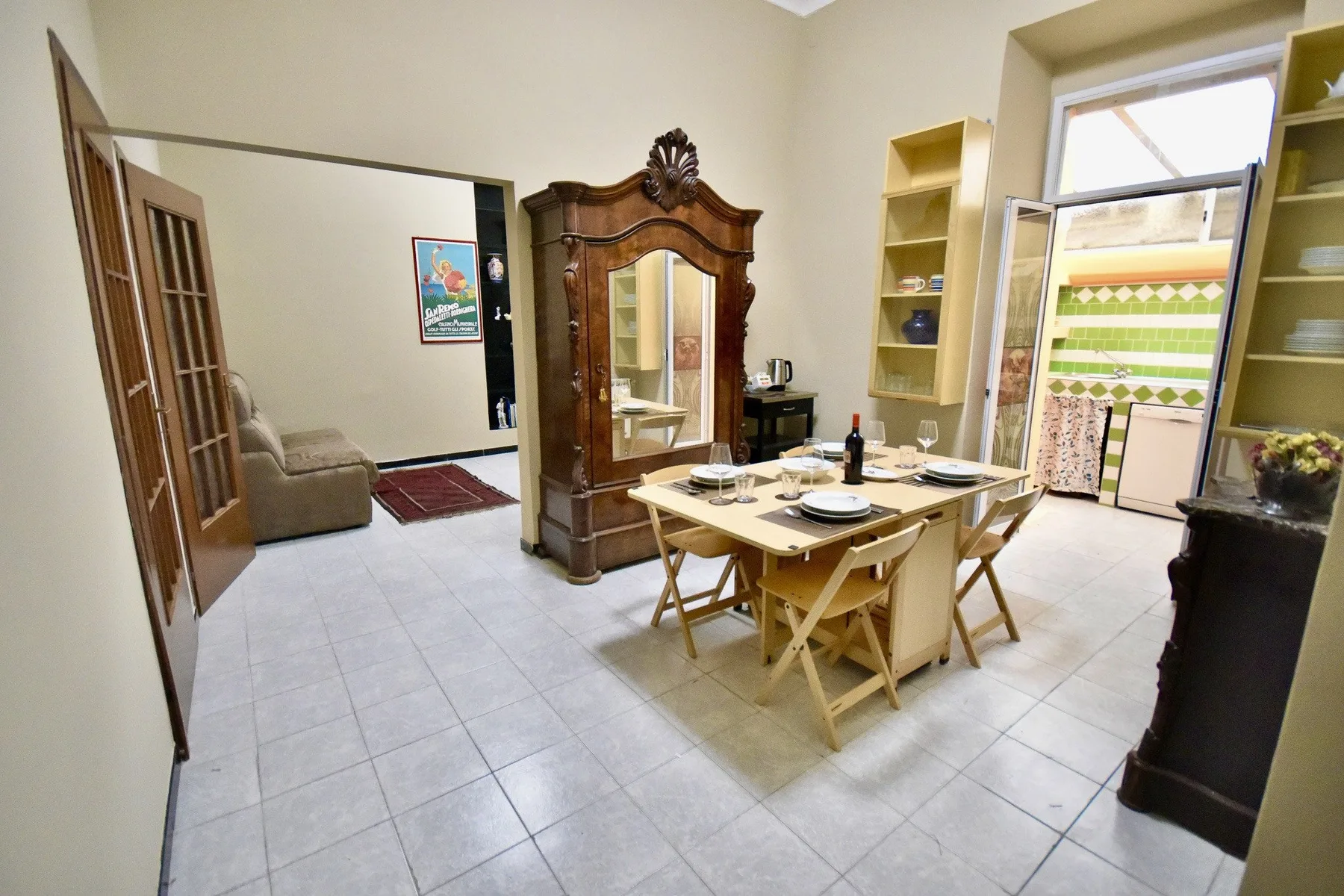 A dining area with a set table and a large wooden cabinet beside a window.