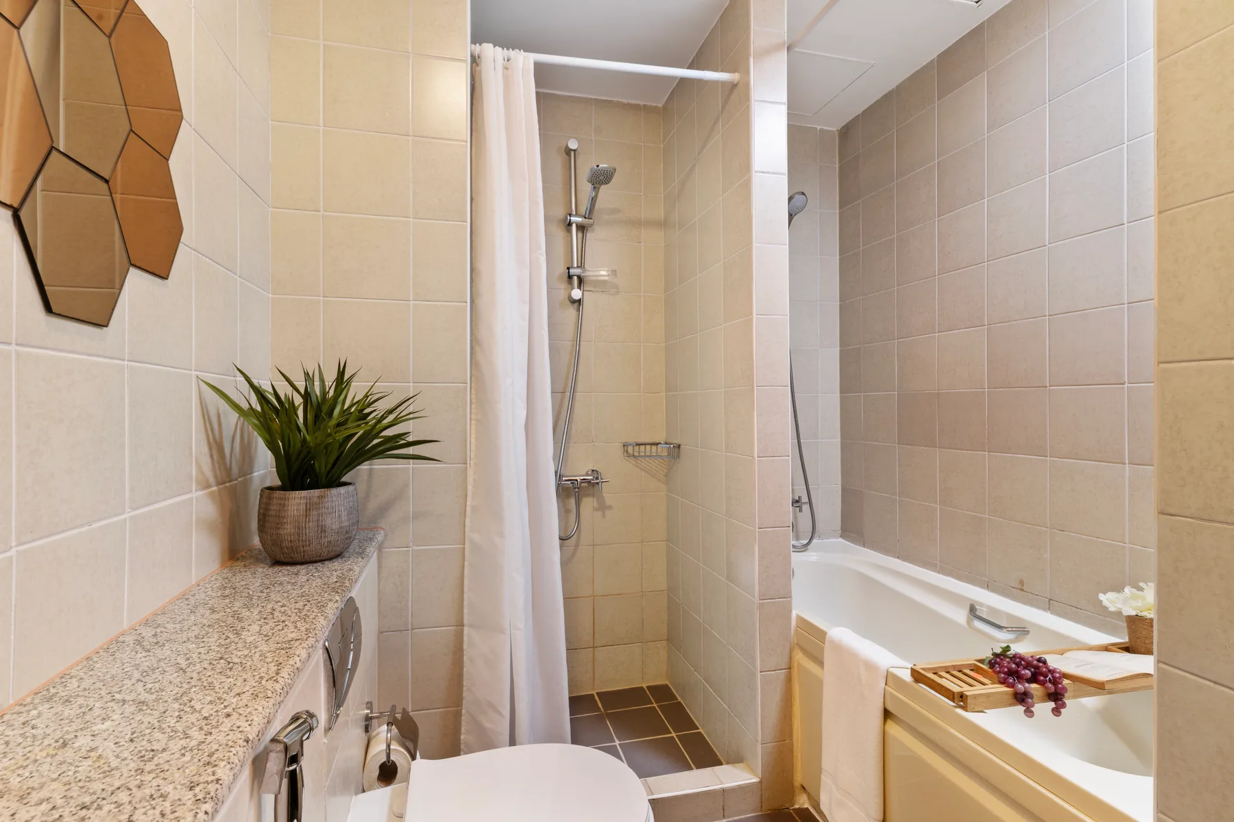 Un baño alicatado con ducha, bañera y lavabo.