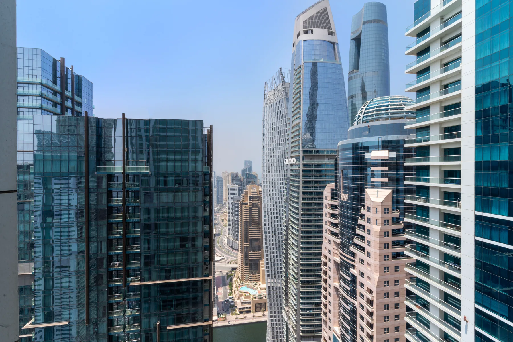 Un horizonte urbano de edificios modernos de gran altura bajo un cielo azul despejado.