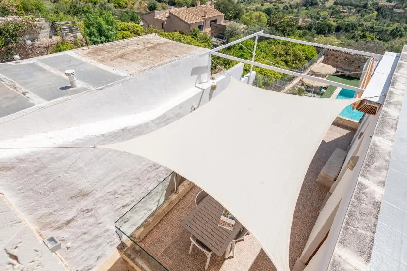 A rooftop terrace with a large shade canopy and outdoor seating.
