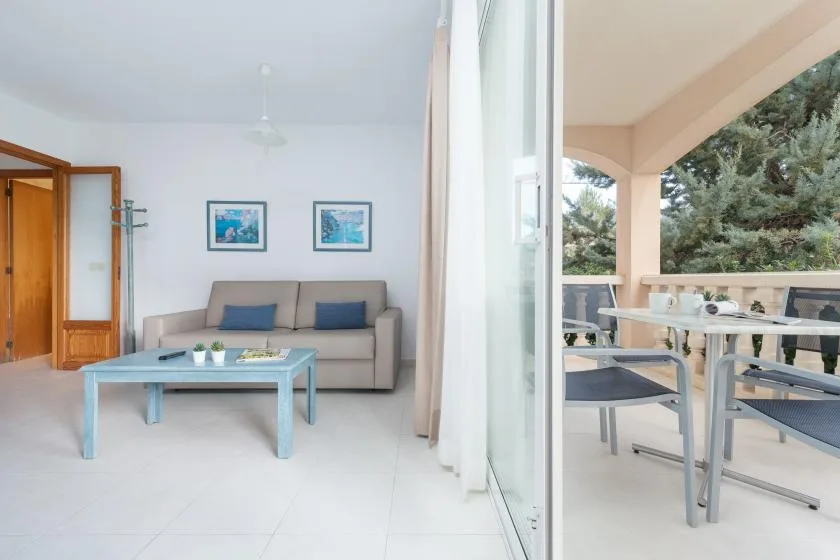 A bright living room opens onto a covered patio with outdoor seating.