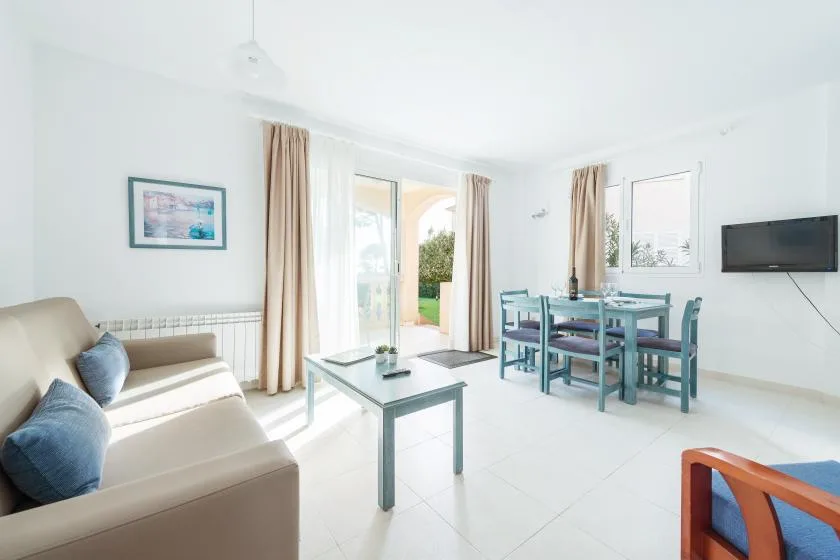 A bright living and dining area with seating, a coffee table, and a dining table.
