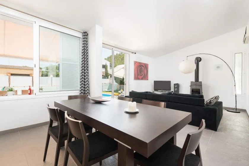 Una luminosa sala-comedor cuenta con una mesa oscura y asientos.