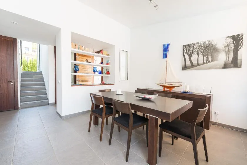 Un comedor con una mesa larga y una estantería empotrada.