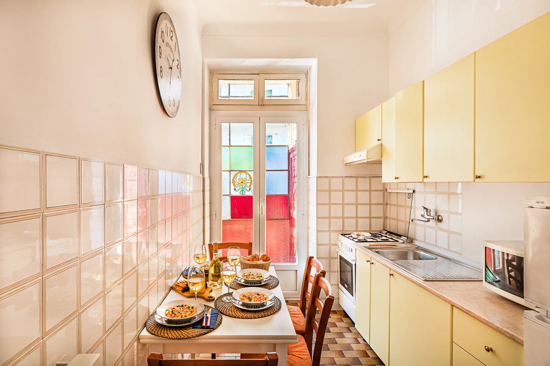 A bright kitchen with a dining table set beside the cooking area.
