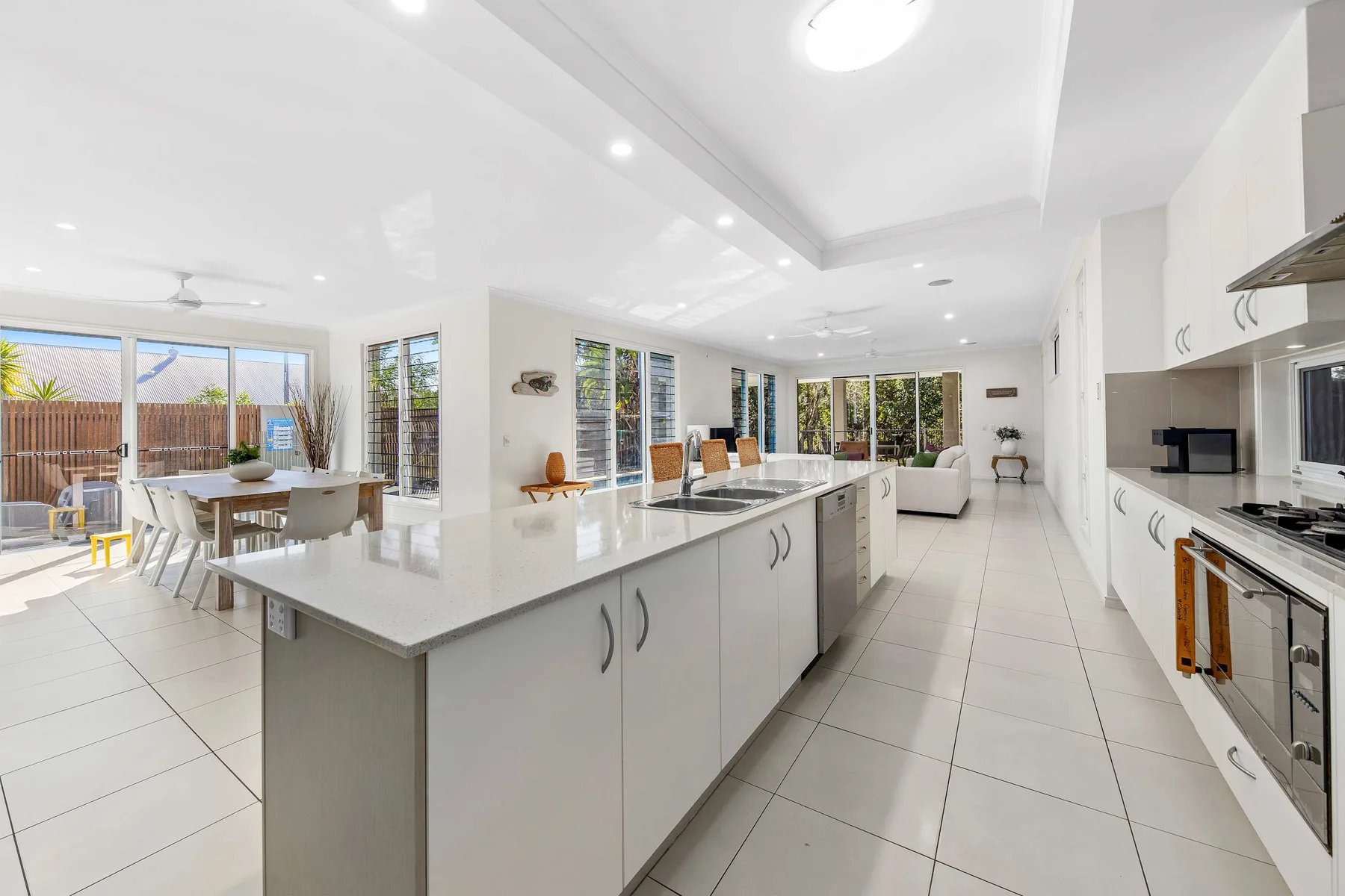 A bright open-plan kitchen and dining area with a long central island.
