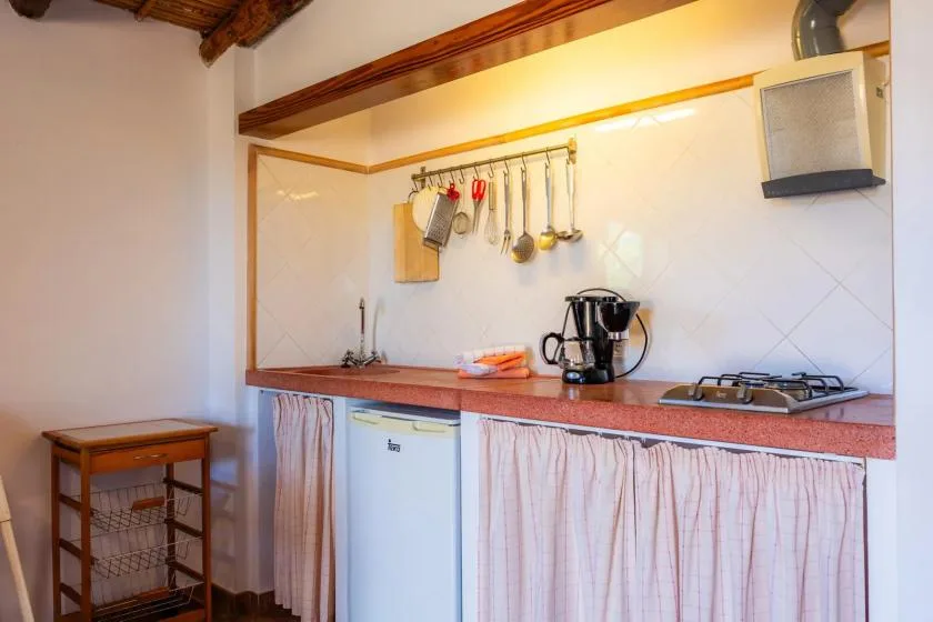 A kitchen counter with a sink, coffee maker, and gas cooktop.