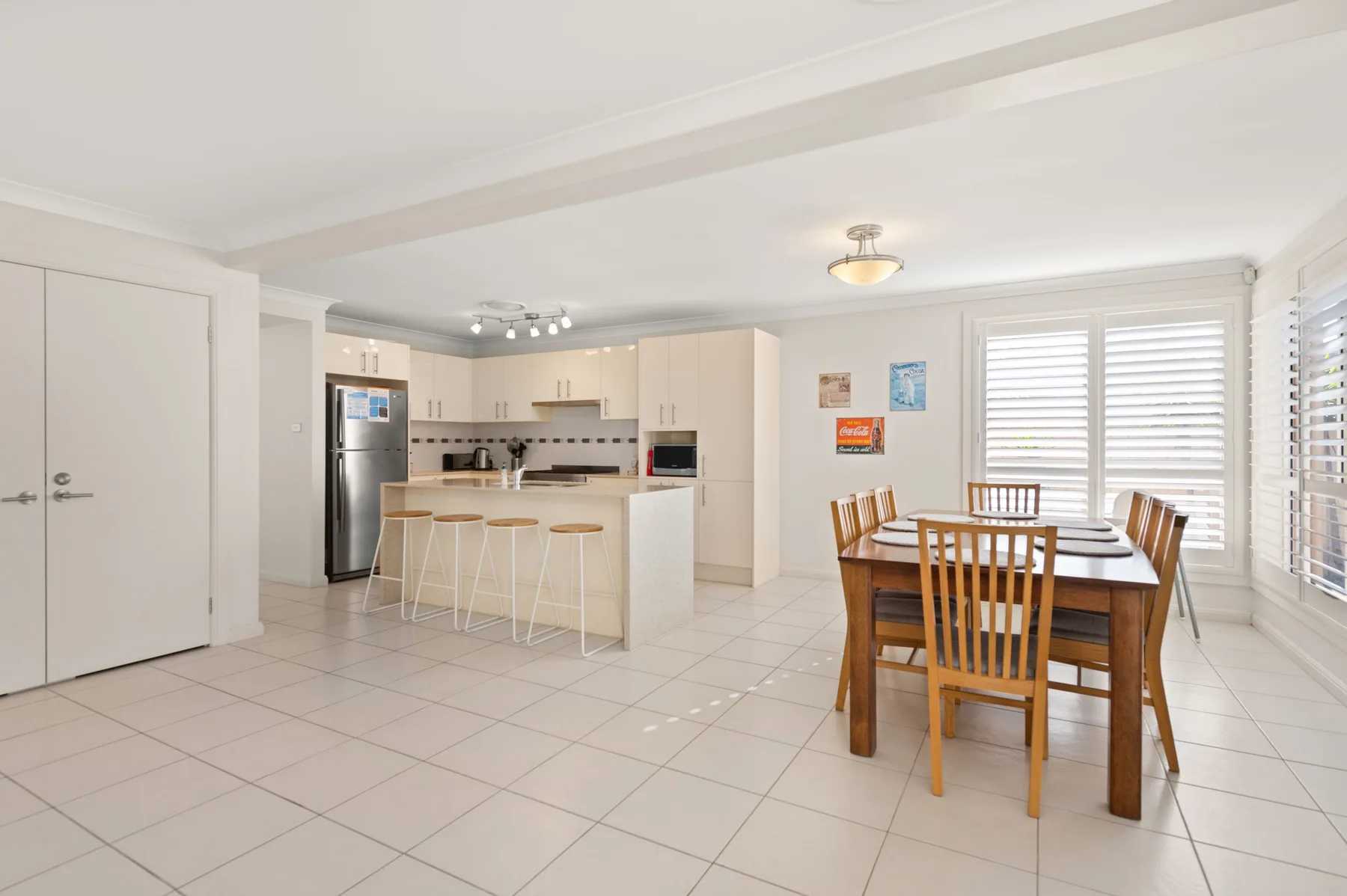 An open kitchen and dining area with a breakfast bar and table.