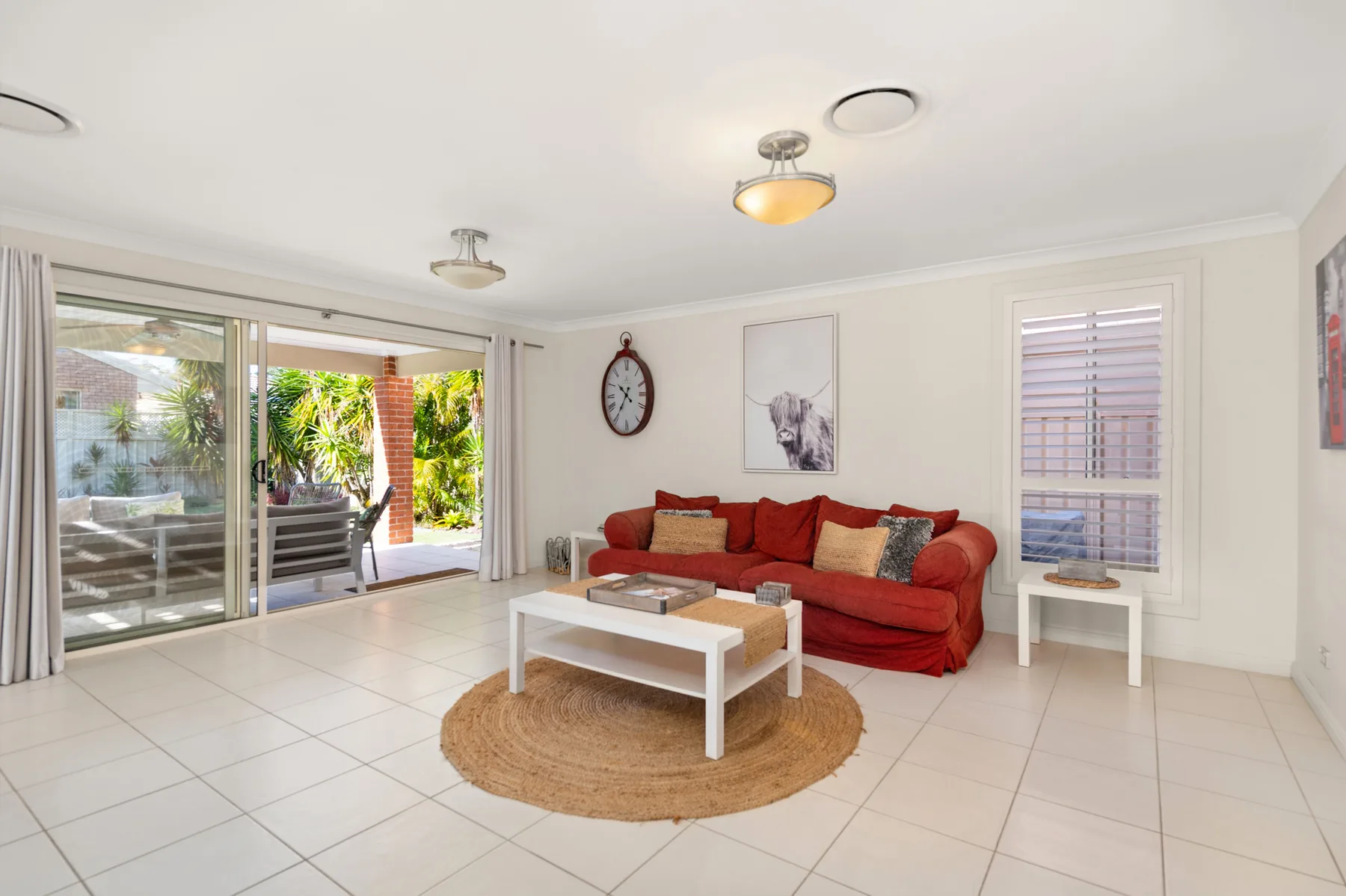A bright living room with red seating and a coffee table.