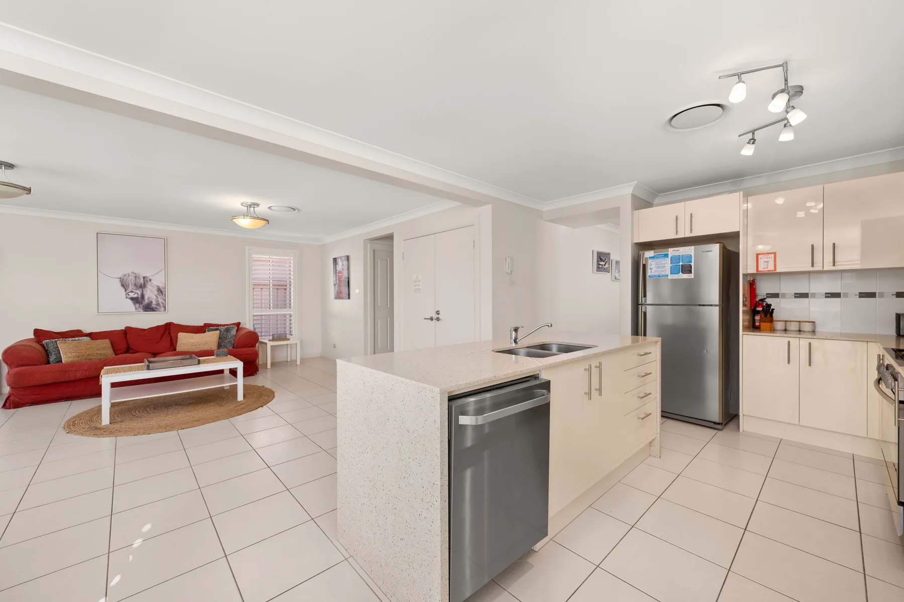 An open-plan kitchen and living area with a red sofa and a large island.