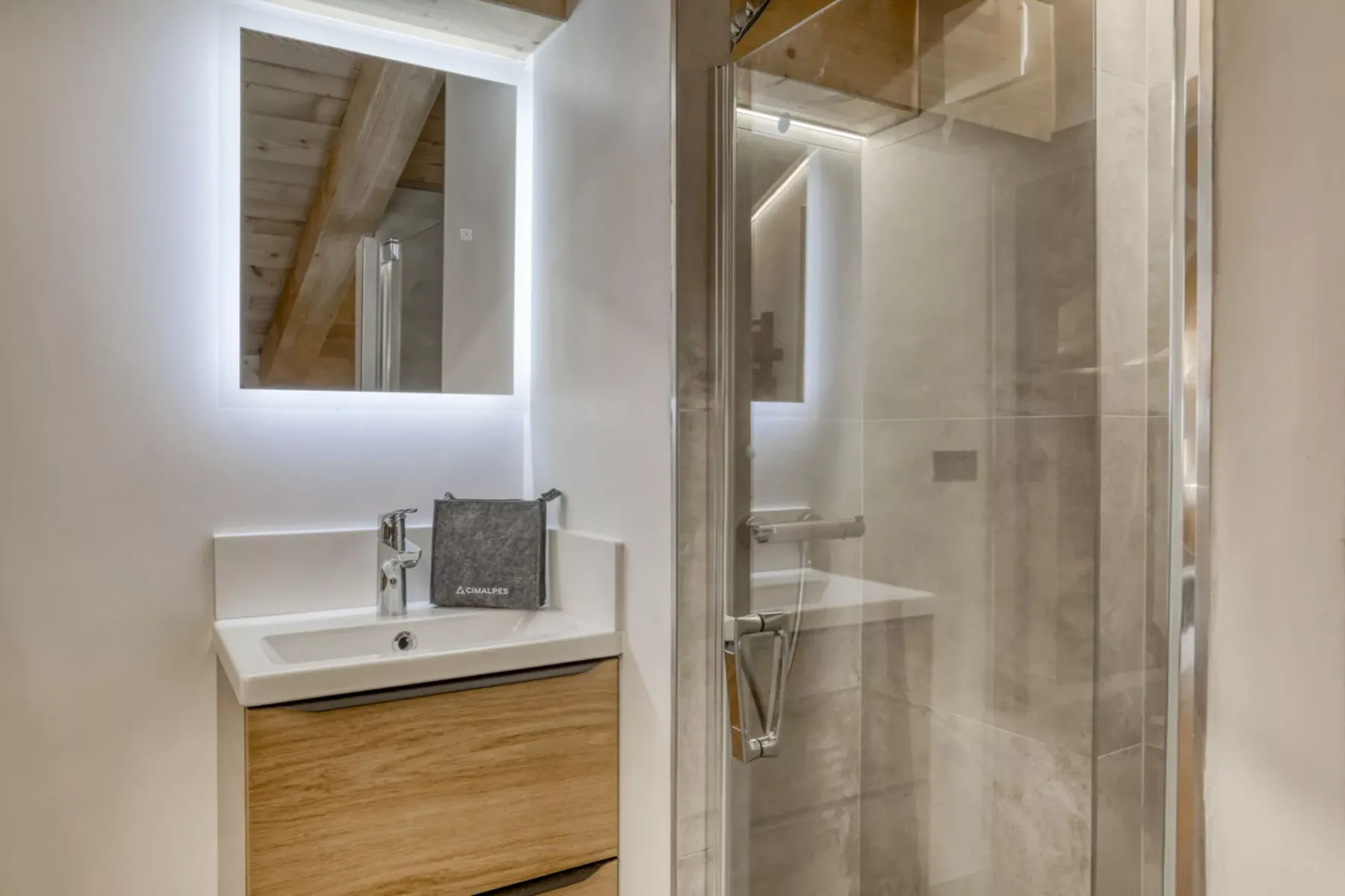 A modern bathroom vanity with a mirror beside a glass shower.