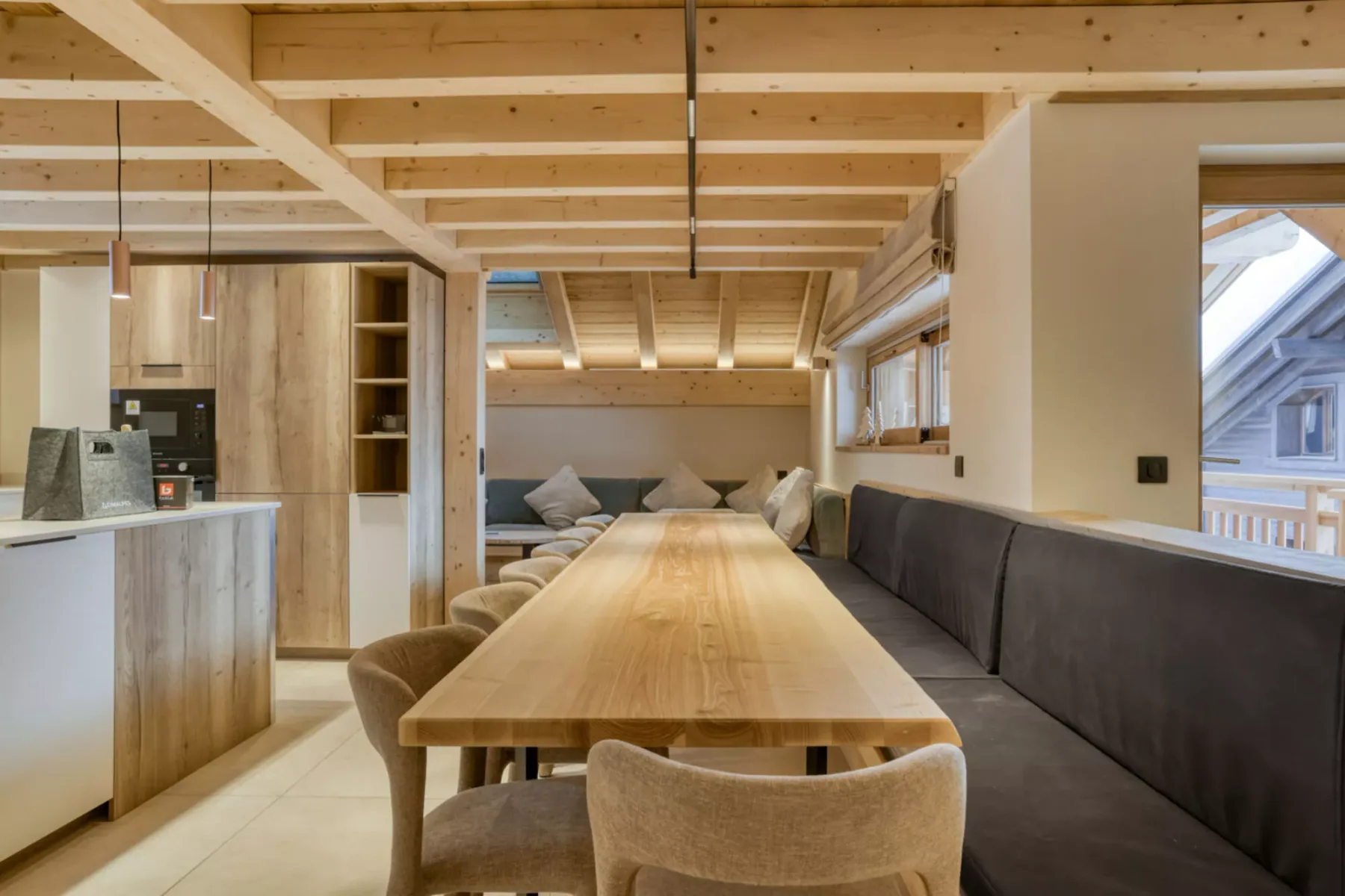 A dining area with a long wooden table and built-in seating.