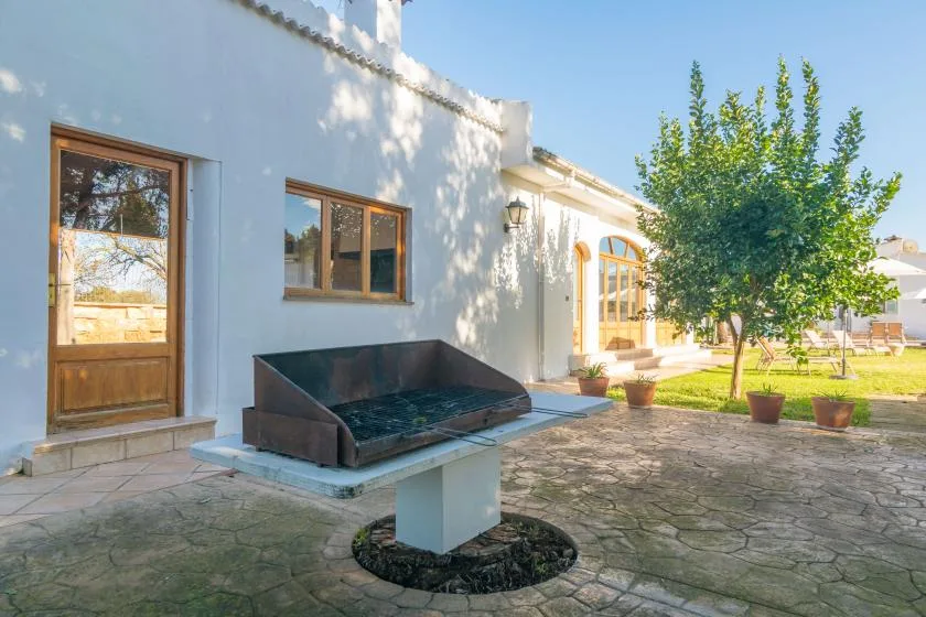 Un edificio blanco da a un patio pavimentado con una pila elevada al aire libre.