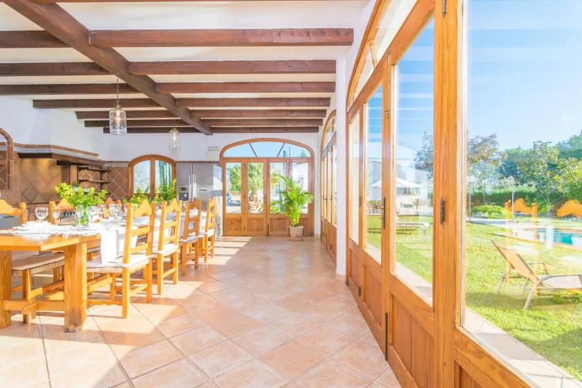 Un comedor luminoso se abre al jardín a través de grandes ventanas y puertas.