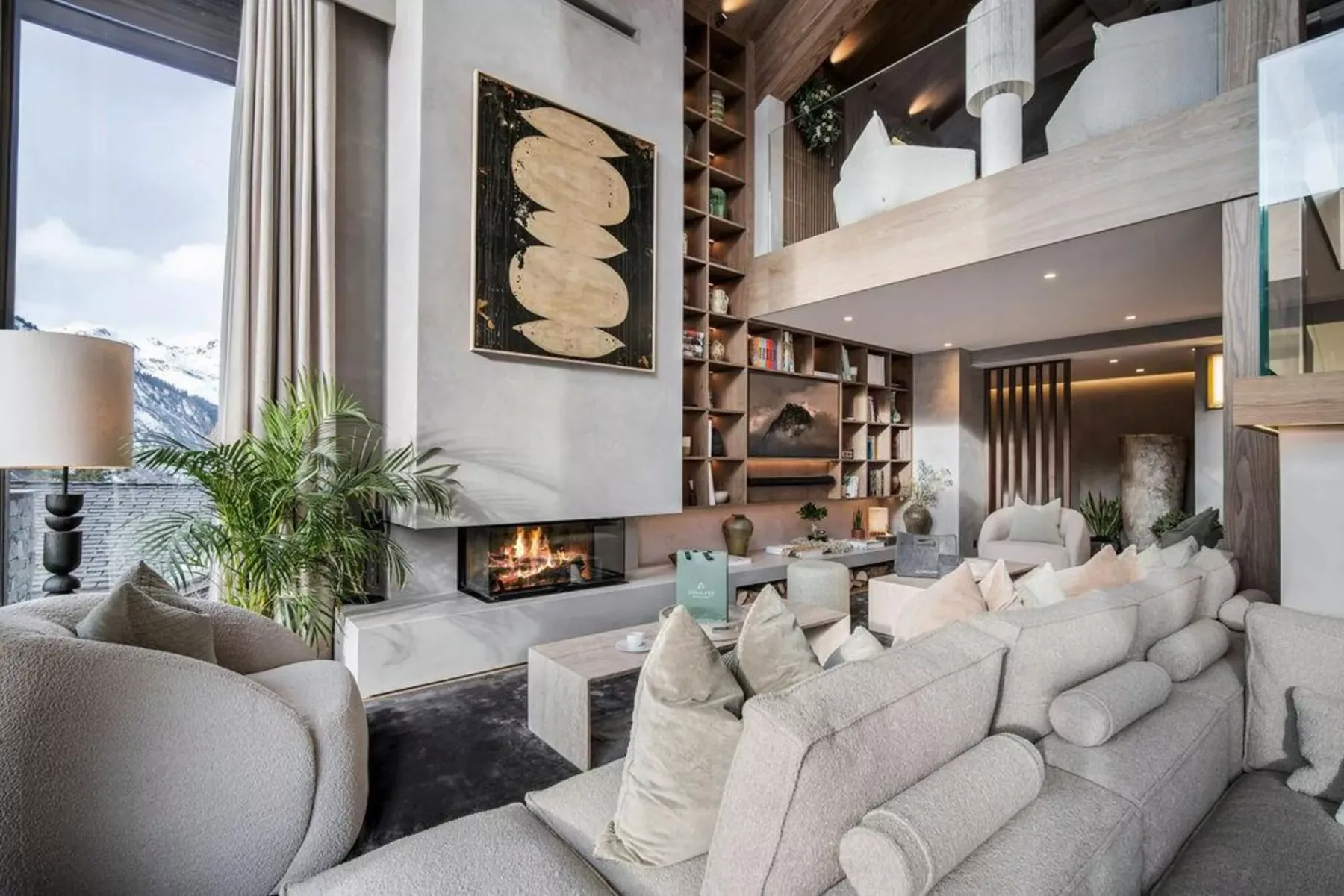 Una sala de estar de doble altura con chimenea y asientos.