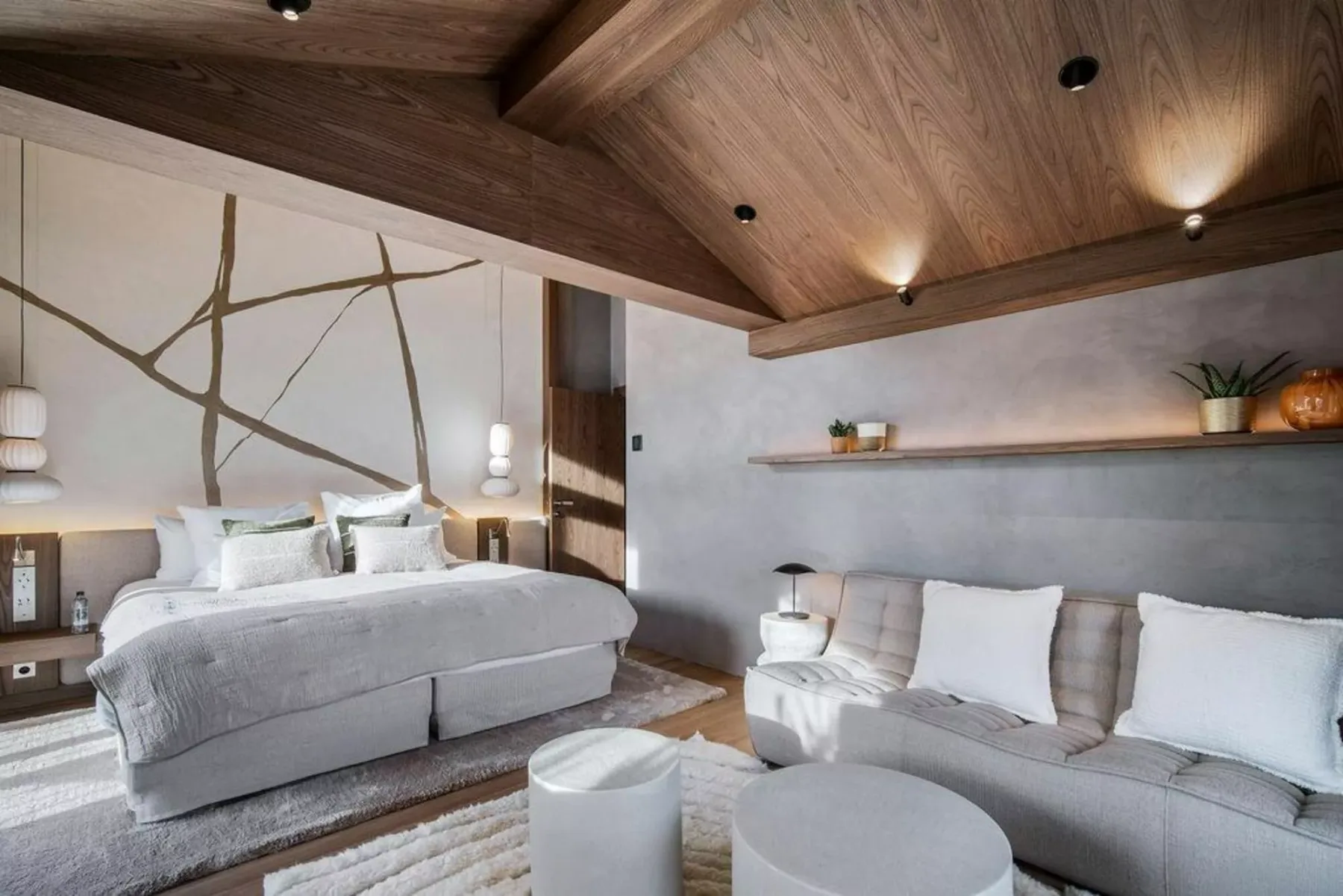 Un dormitorio con cama y asientos bajo un techo de madera.