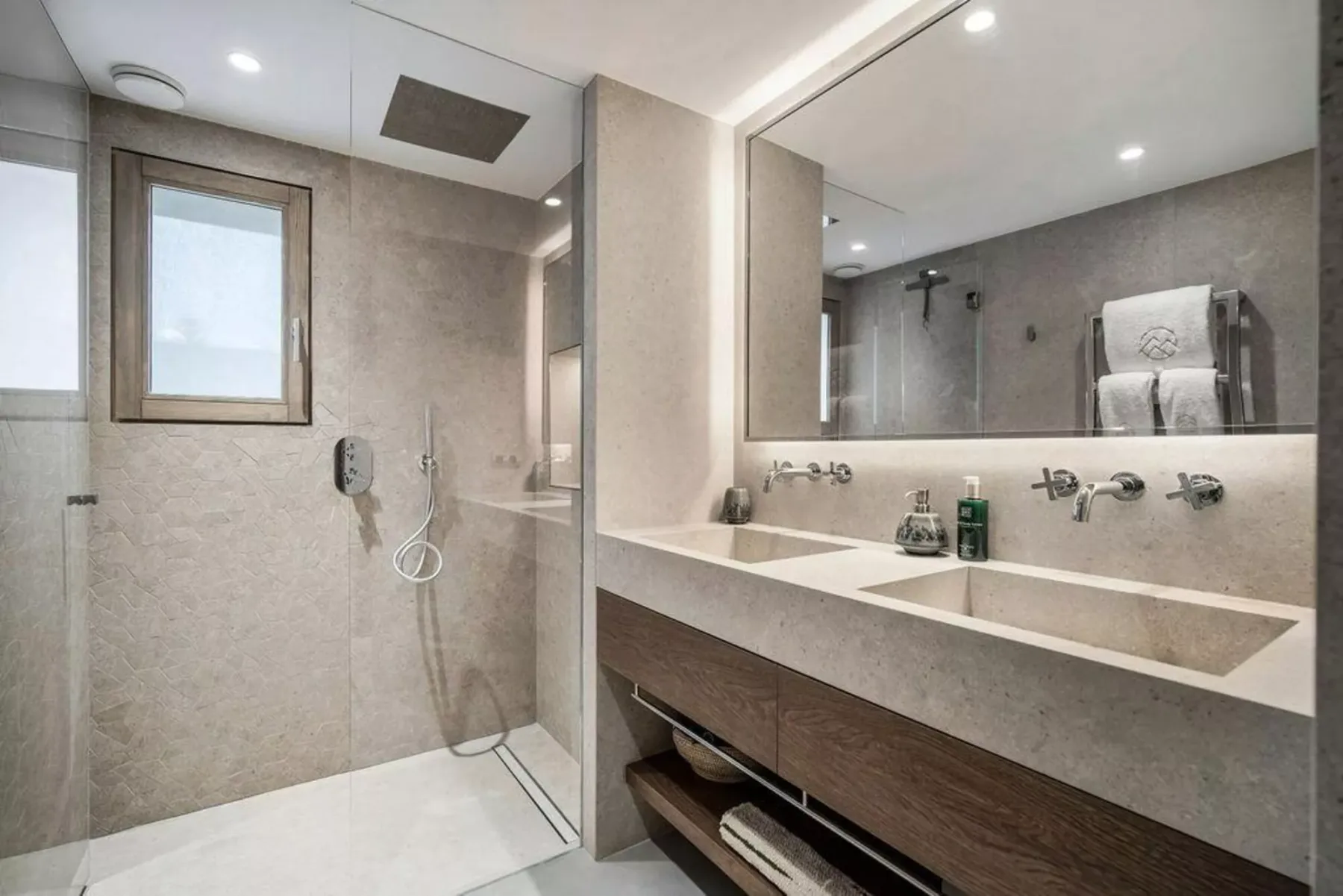 Un baño moderno con una ducha de vidrio y una amplia encimera con lavabo.