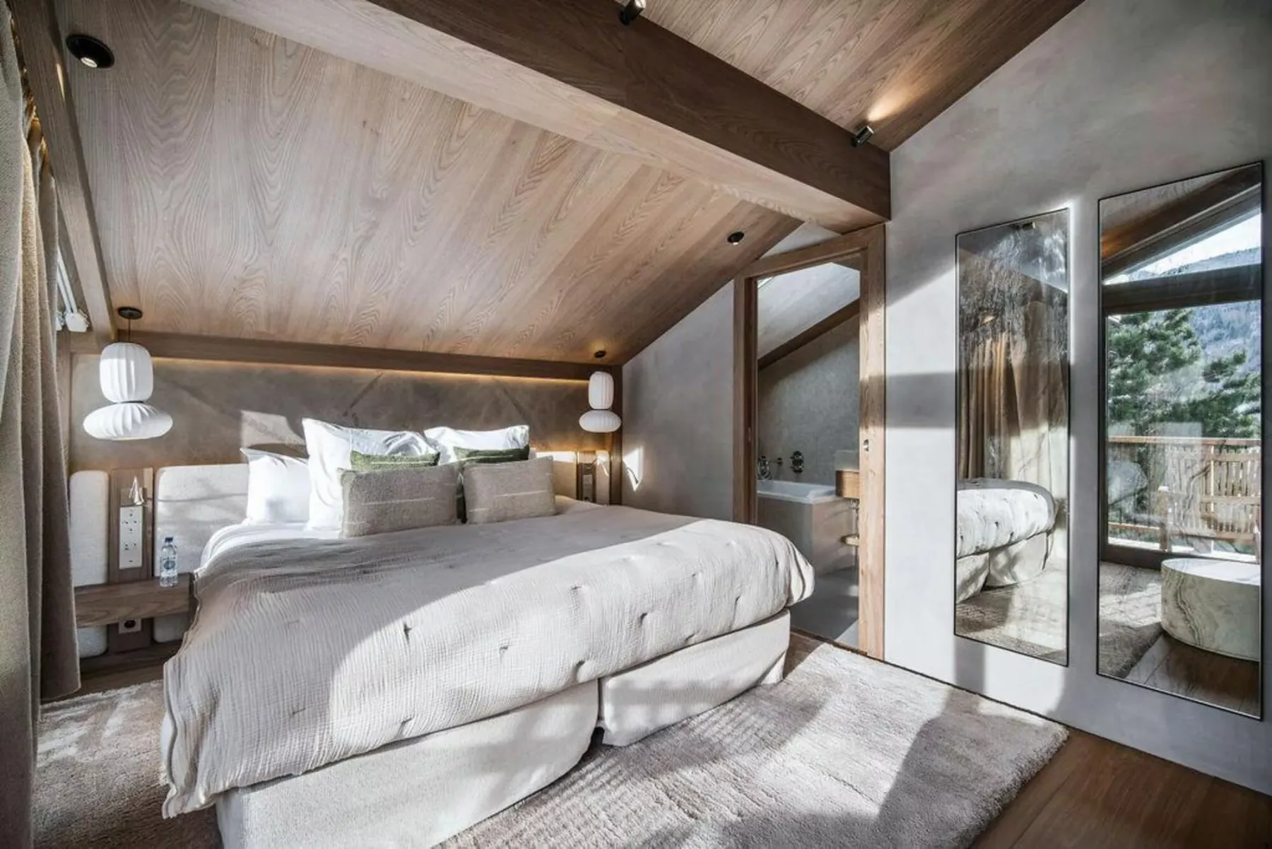 Un dormitorio luminoso con una cama grande y una puerta de vidrio que da a un balcón.