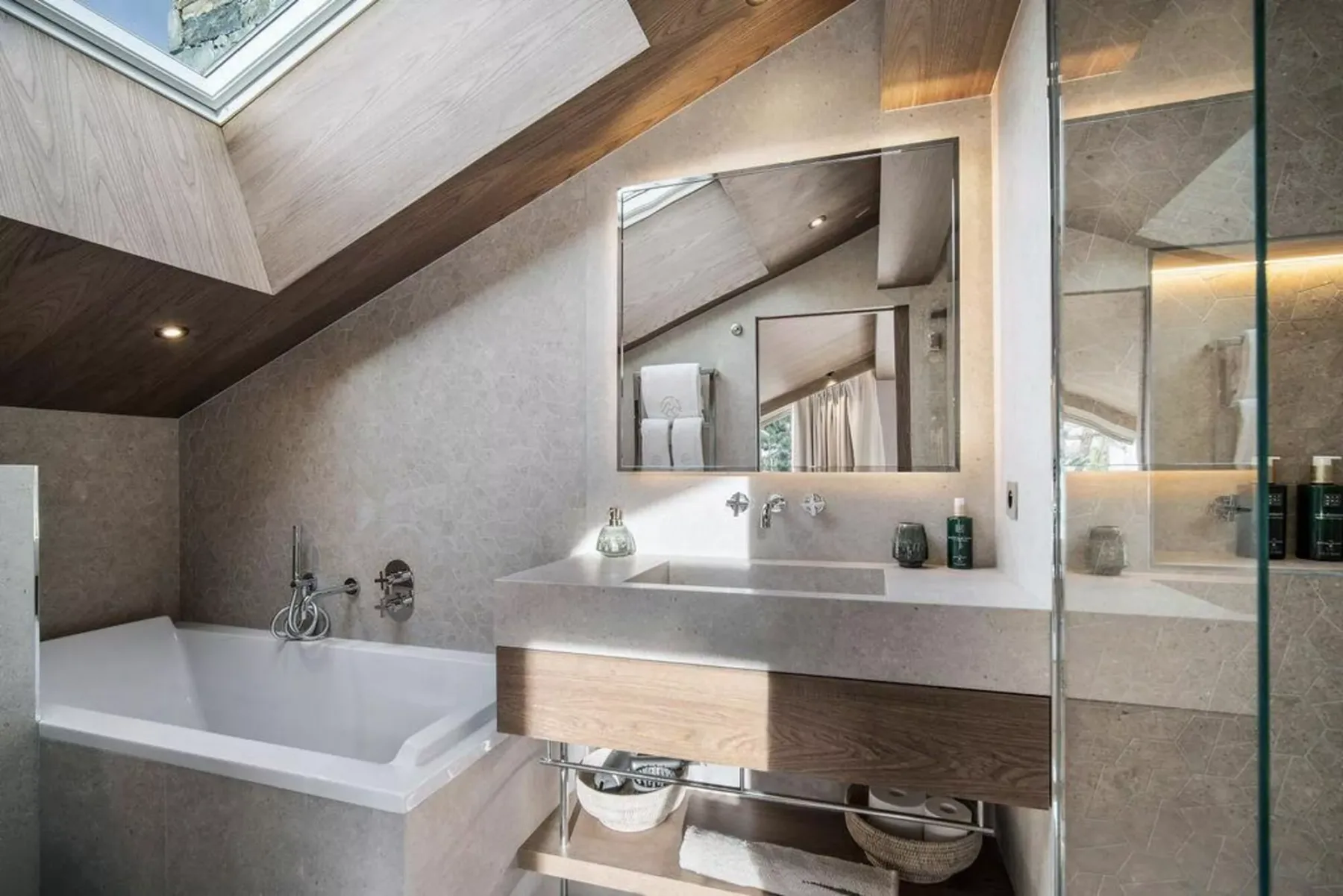 Un baño con bañera, lavabo y claraboya.