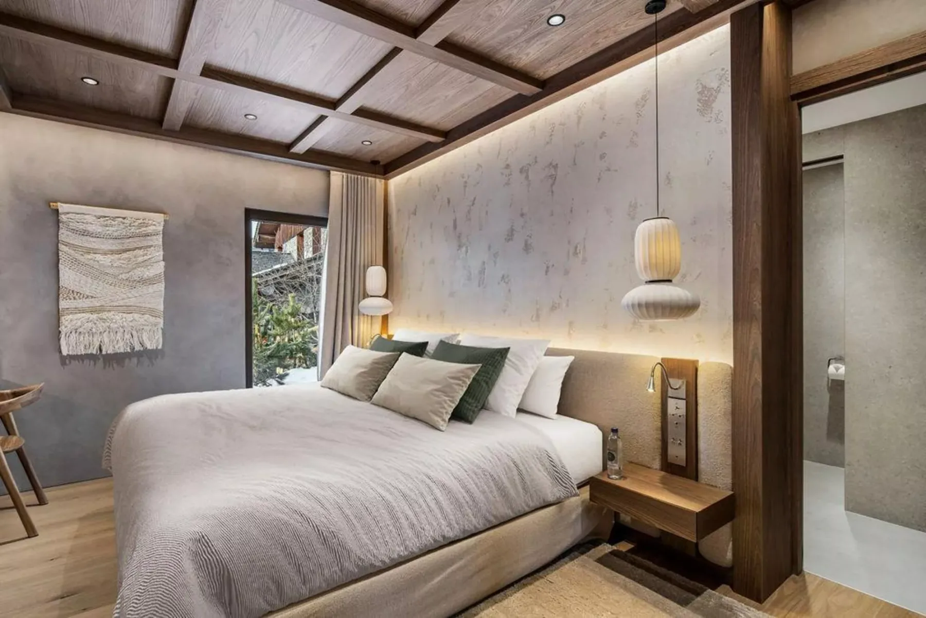 Un dormitorio con una cama grande, lámparas colgantes y techo con paneles de madera.