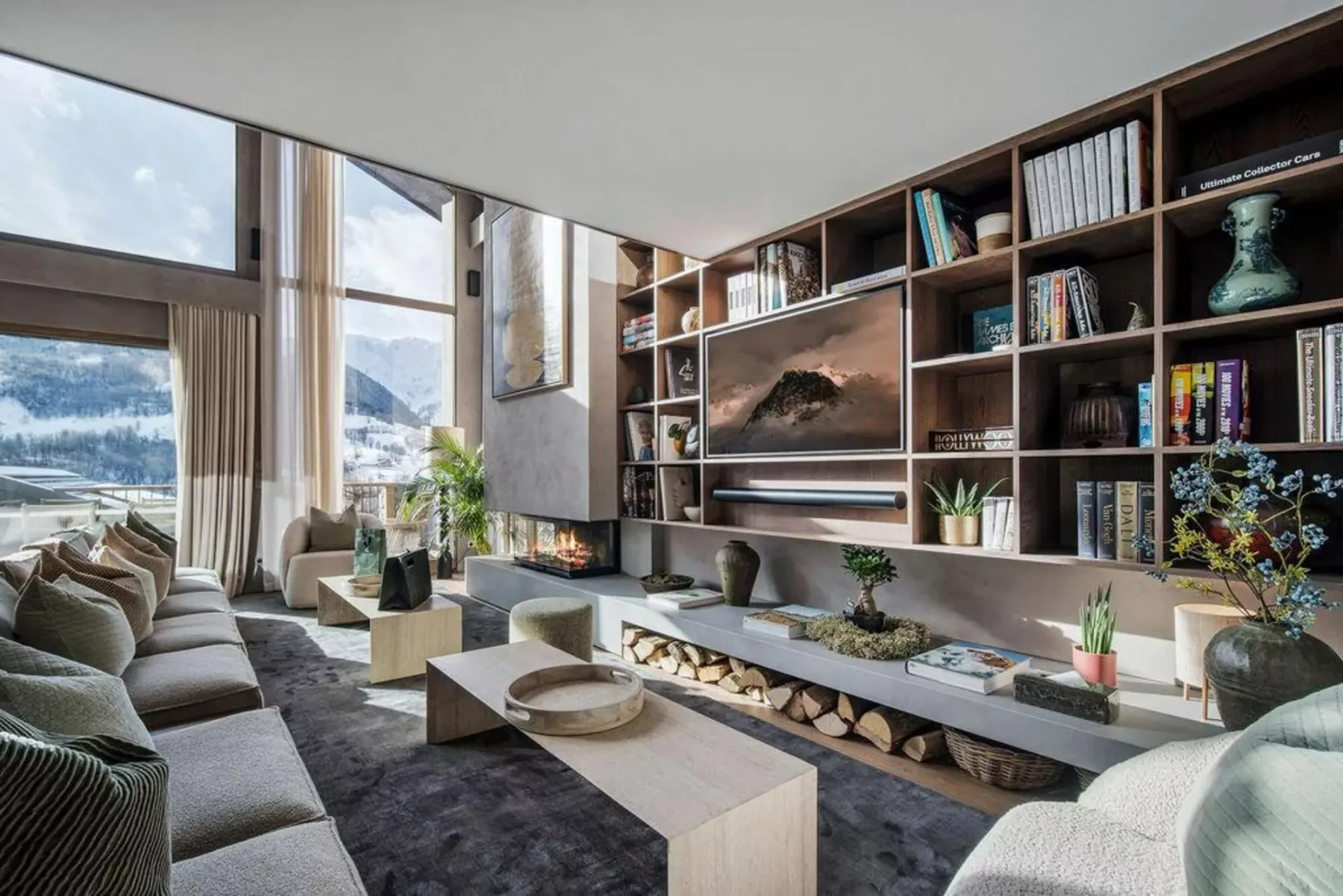 Una sala de estar moderna con ventanas de piso a techo y estanterías empotradas.