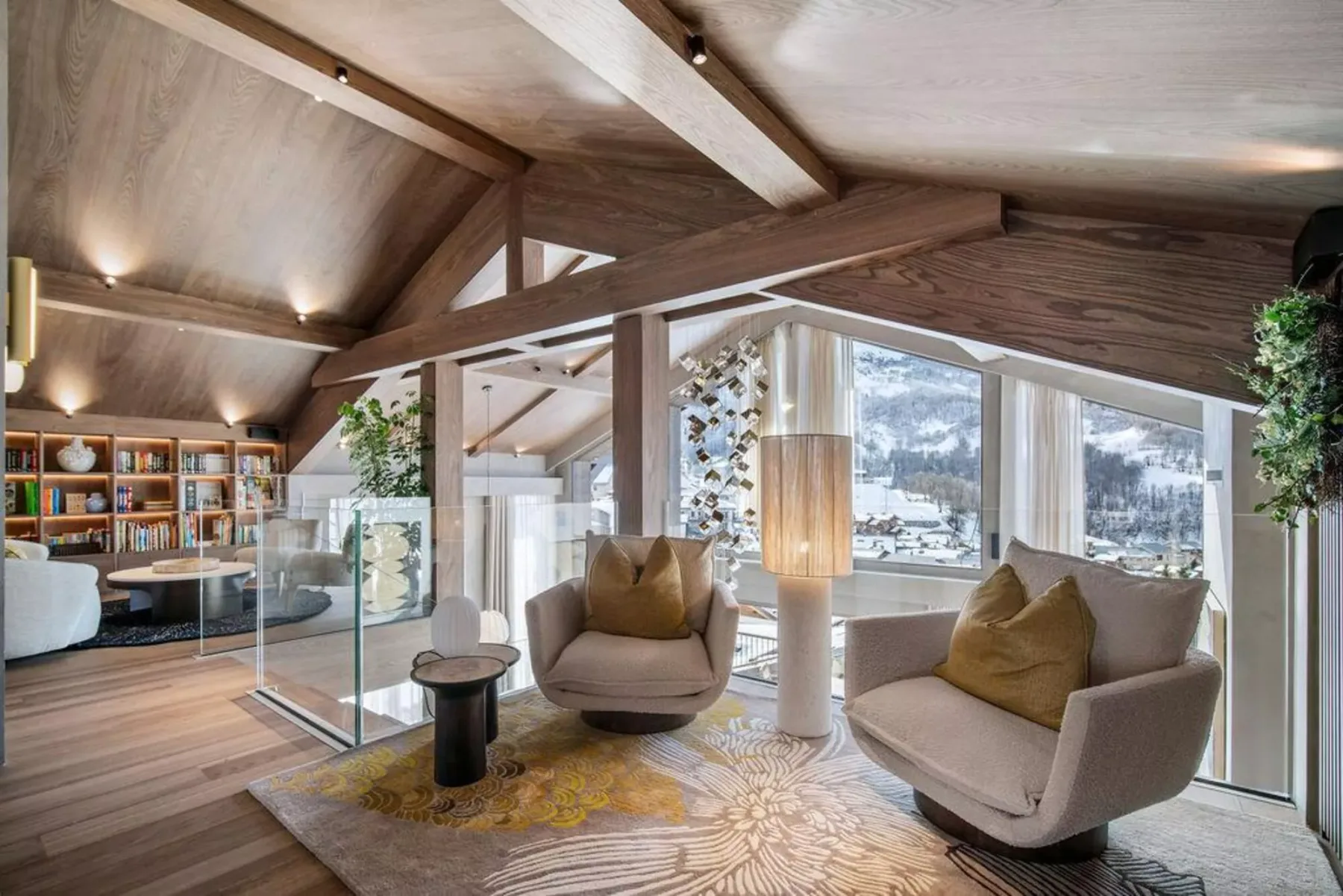 Una sala luminosa con asientos, grandes ventanas y vigas de madera a la vista.