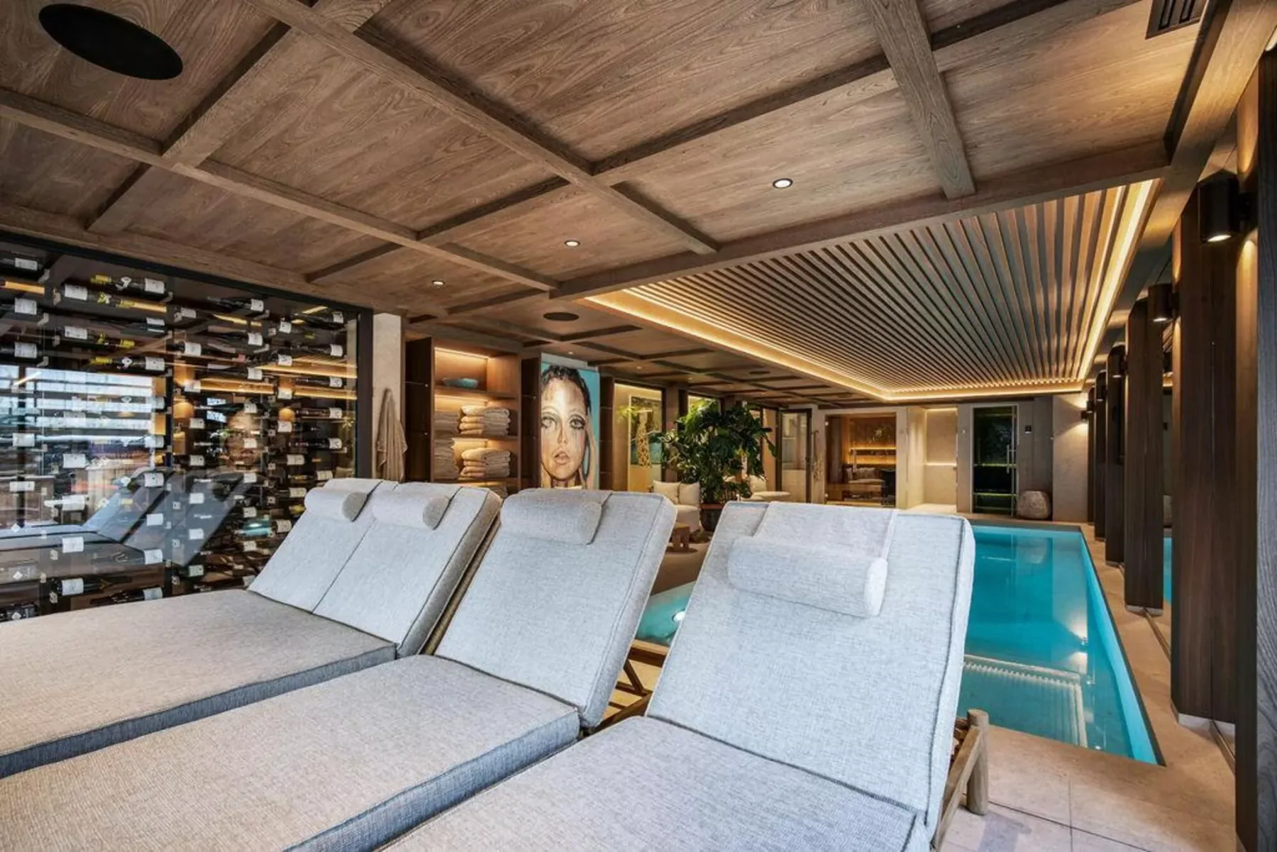 Zona de piscina interior con asientos acolchados junto al agua.