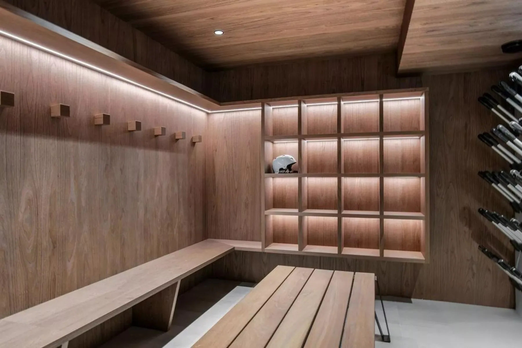 Una sala revestida de madera con estantes empotrados y un banco largo.
