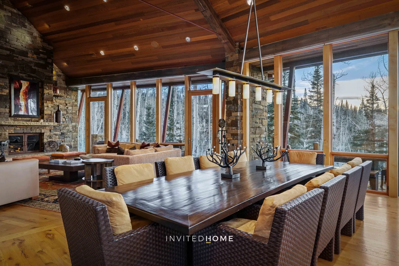 A spacious dining area with a large table beside floor-to-ceiling windows.