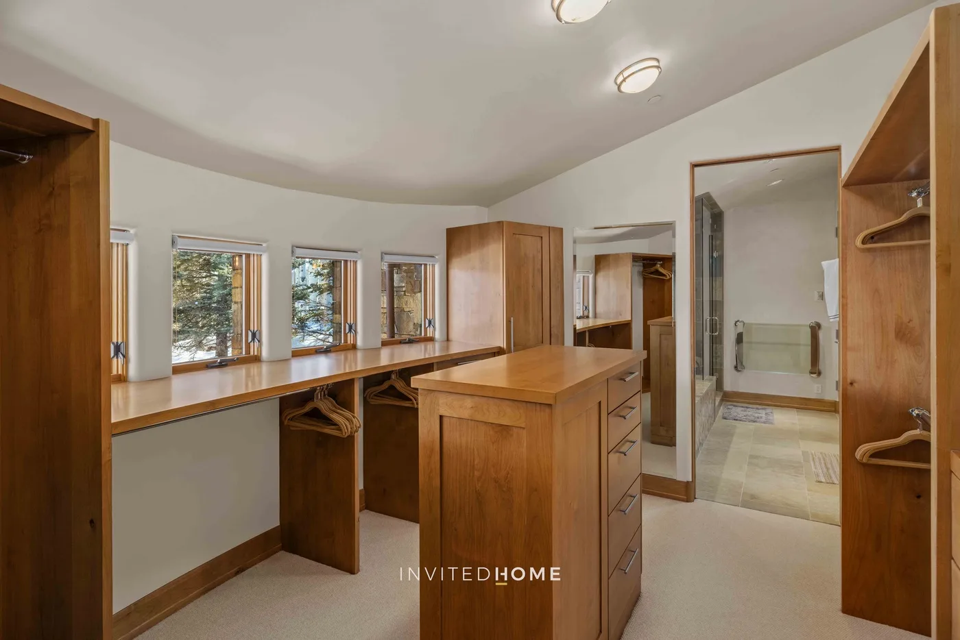 A dressing room with wooden cabinetry and a central island.