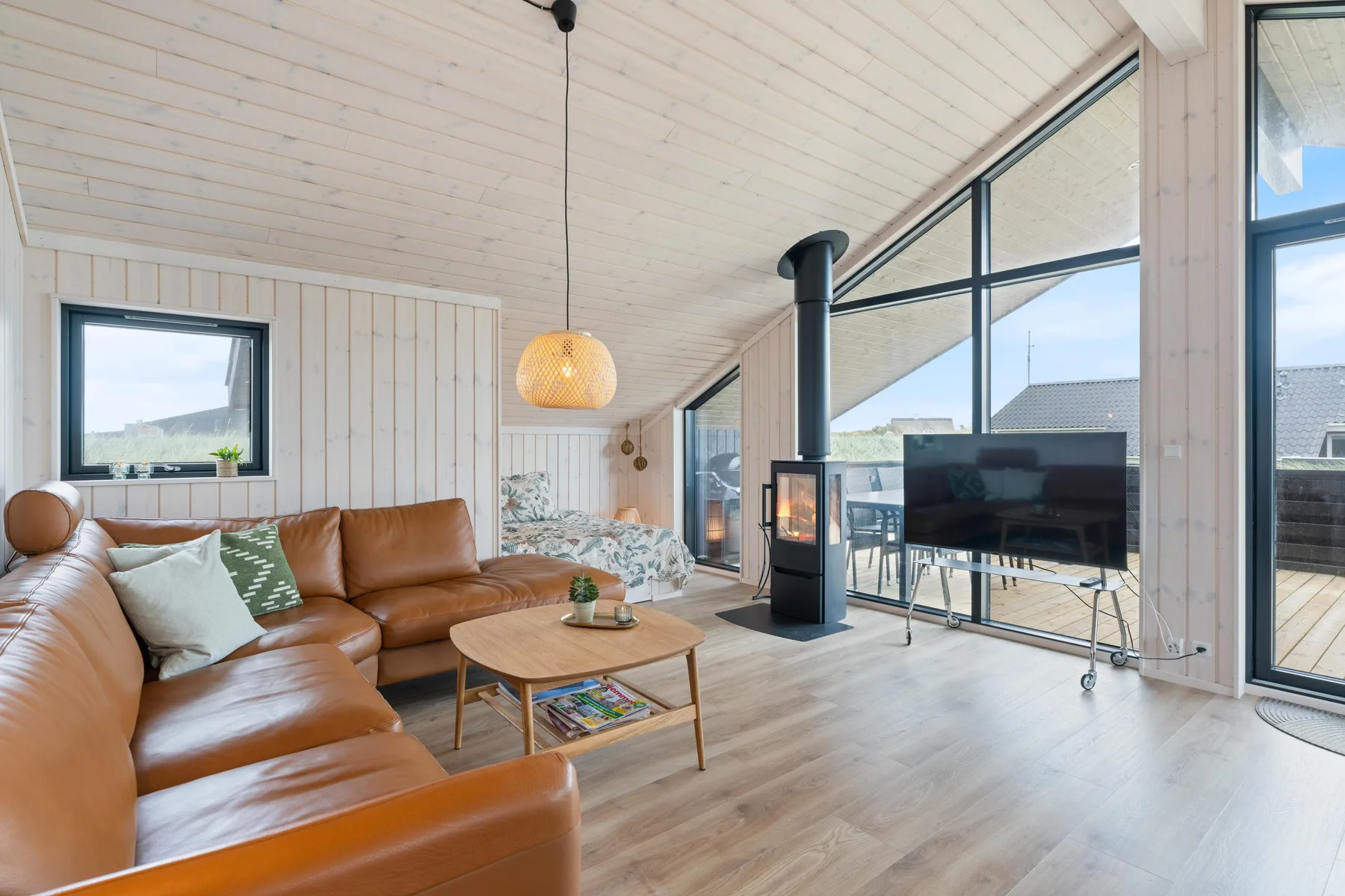 A bright living room with leather seating and large windows.