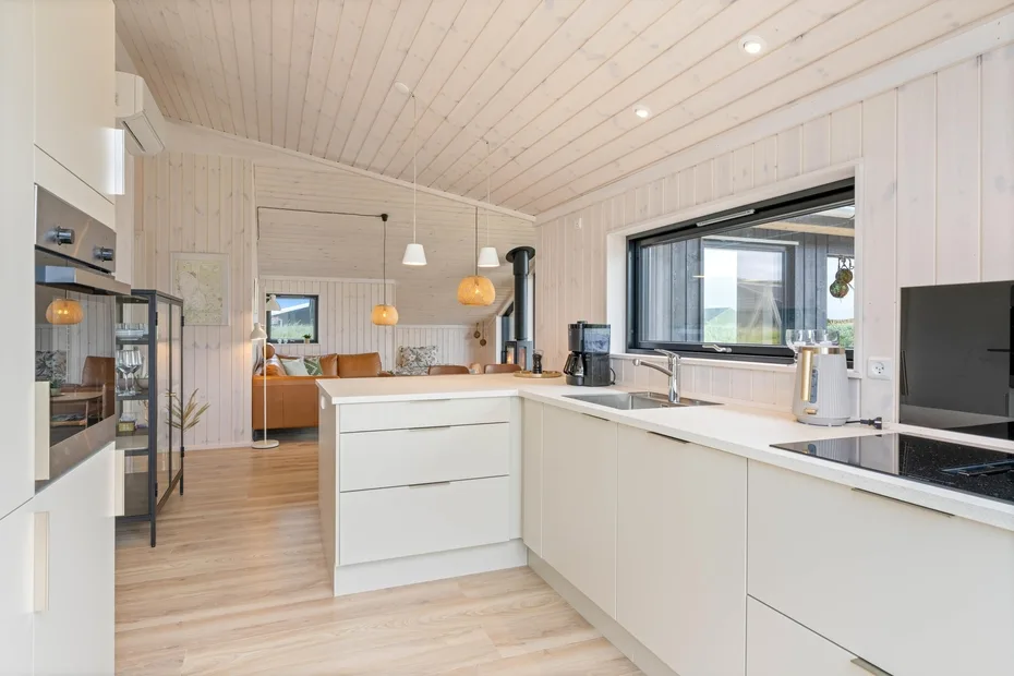 A bright open-plan kitchen with white cabinetry and a central island.