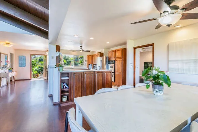 An open kitchen and dining area with wooden cabinets and a large table.
