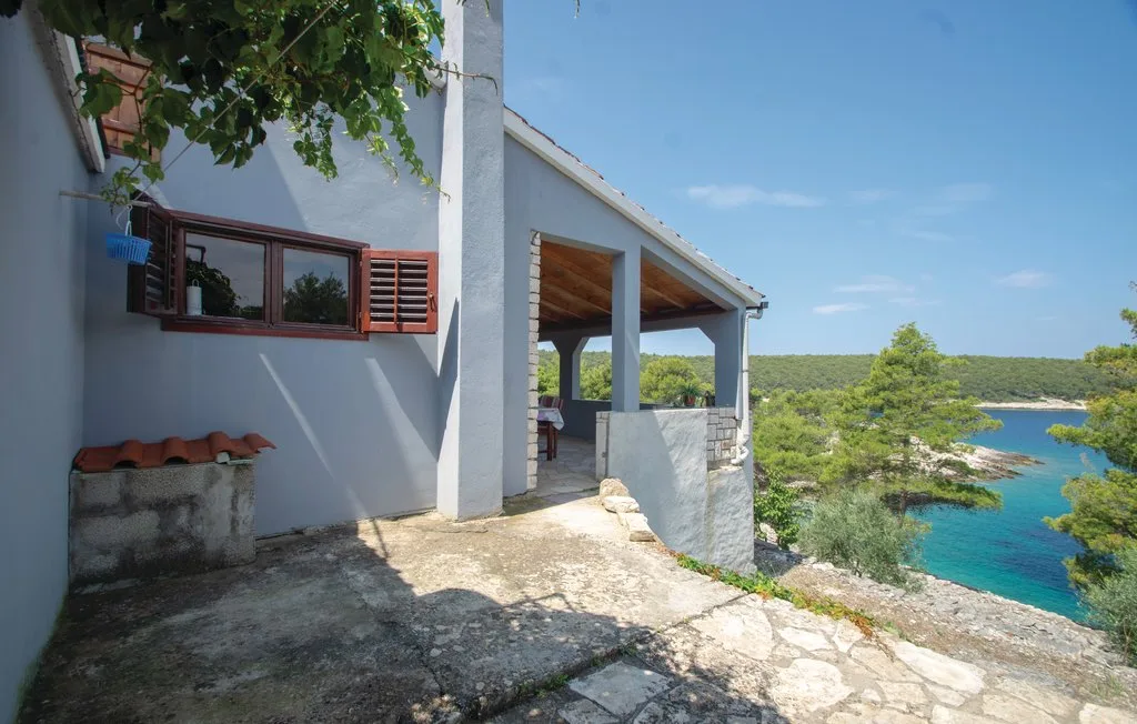 Una terraza junto a la costa ofrece vistas al agua turquesa y la vegetación.