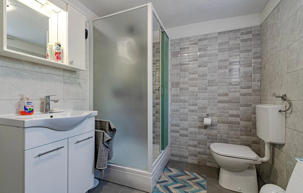 Un baño con lavabo, ducha e inodoro.