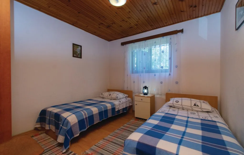 Un dormitorio con dos camas y una ventana entre ellas.