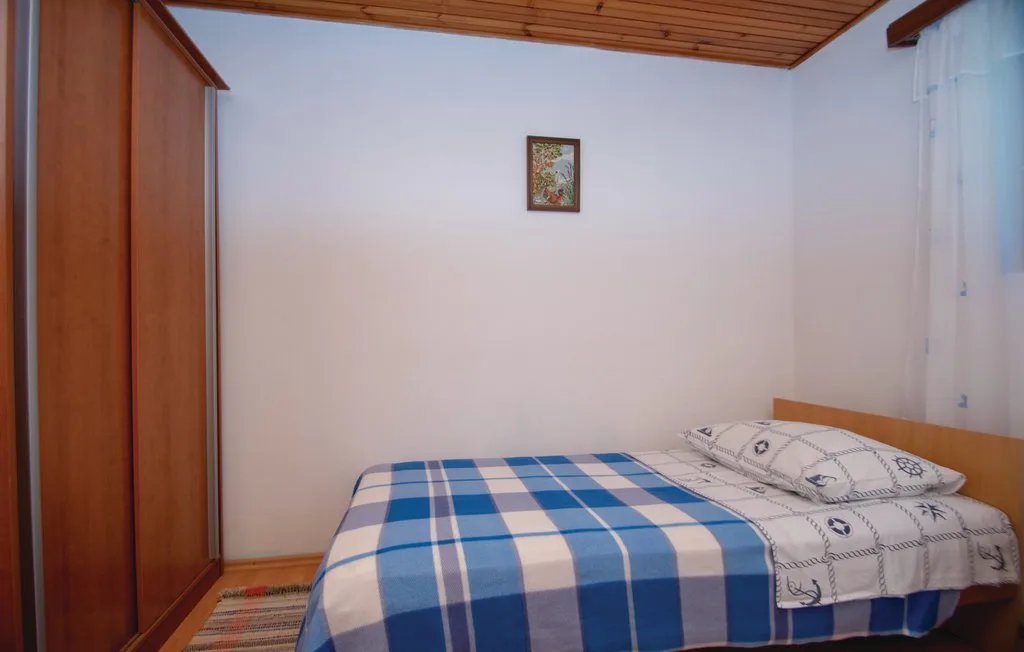 Un dormitorio con una cama cubierta con ropa de cama de cuadros azules y blancos.