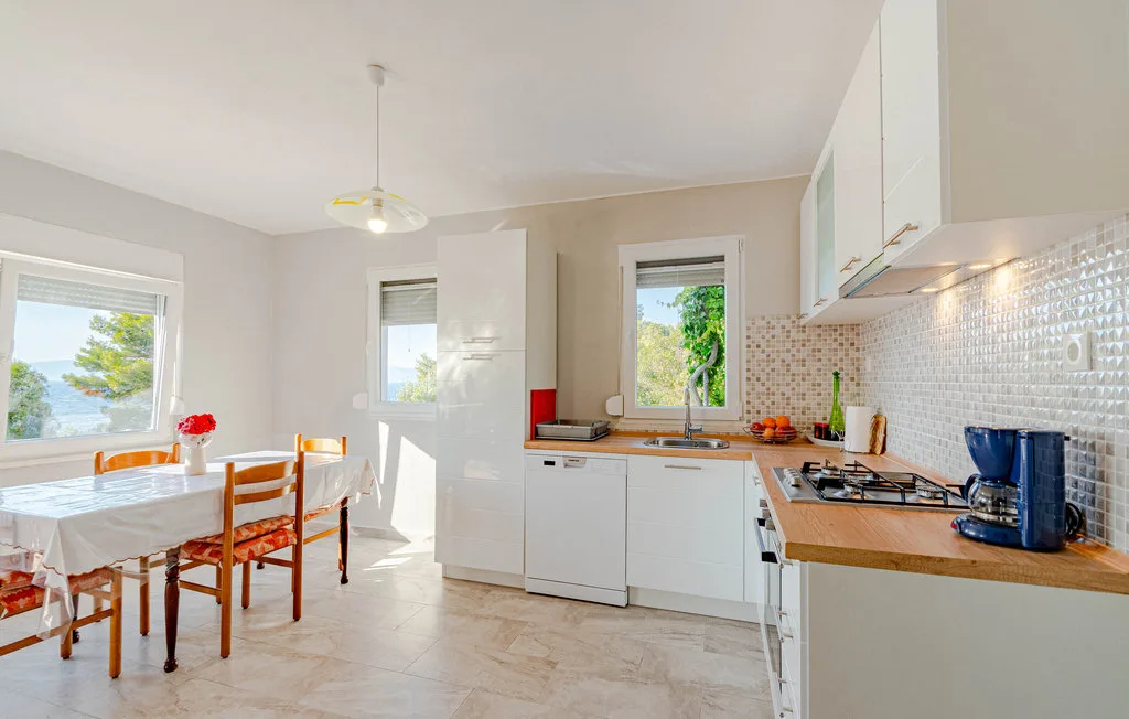 Una cocina luminosa con una mesa de comedor junto a la encimera.