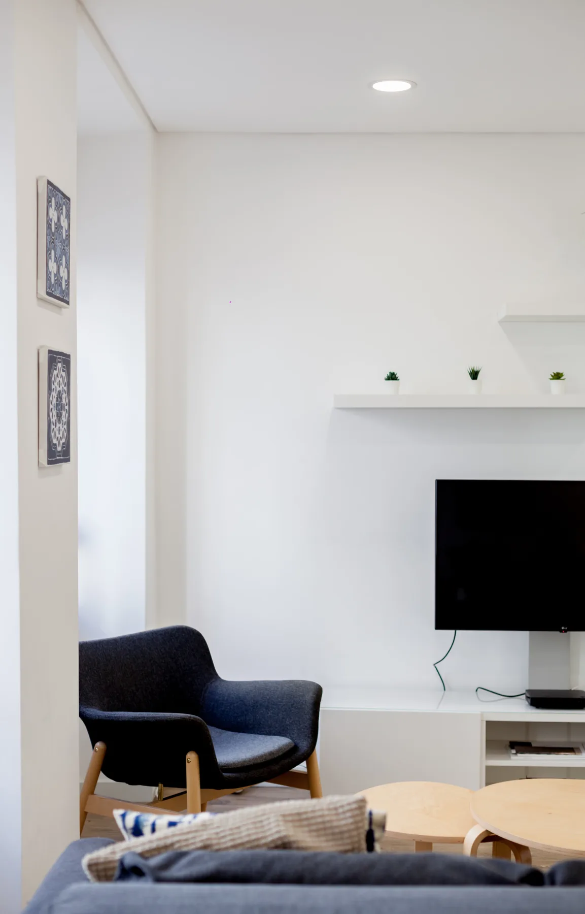 Living room with a dark armchair and wall-mounted television.
