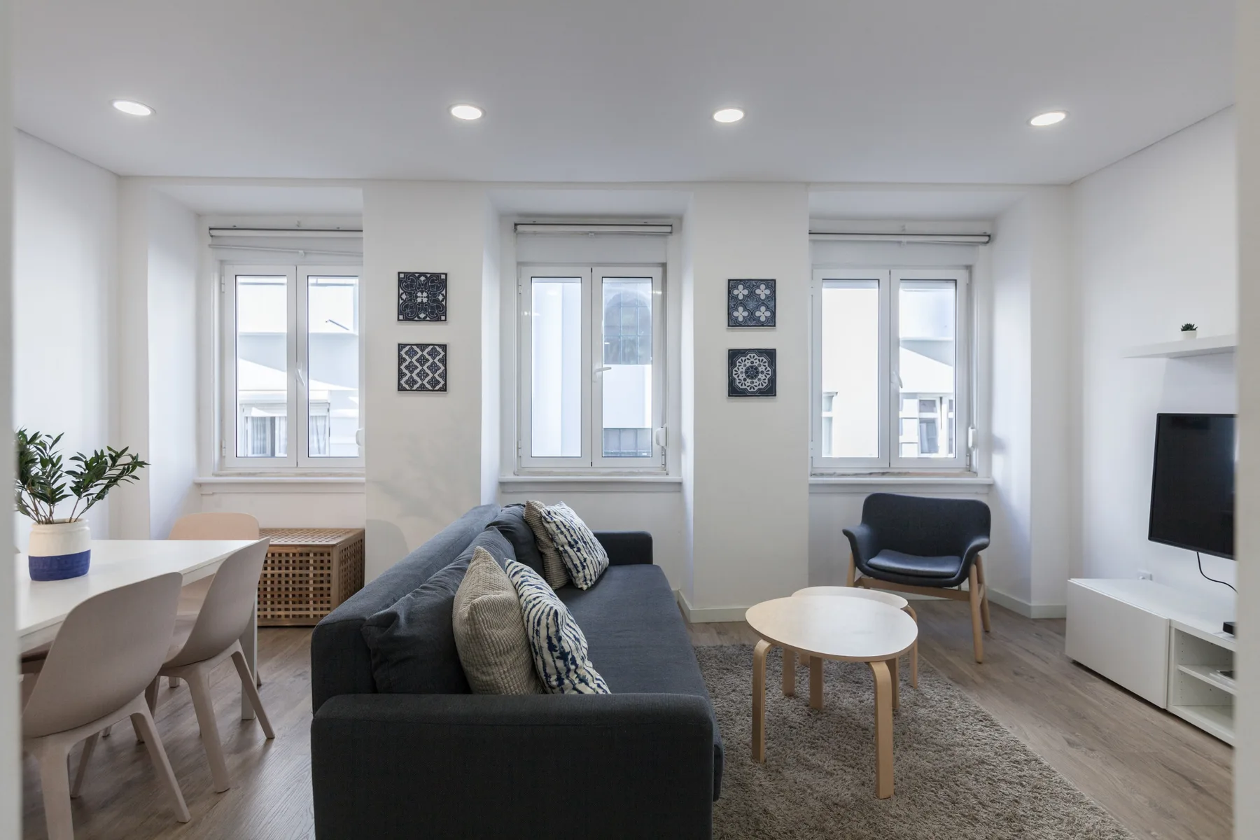 A bright living room with seating, a coffee table, and large windows.