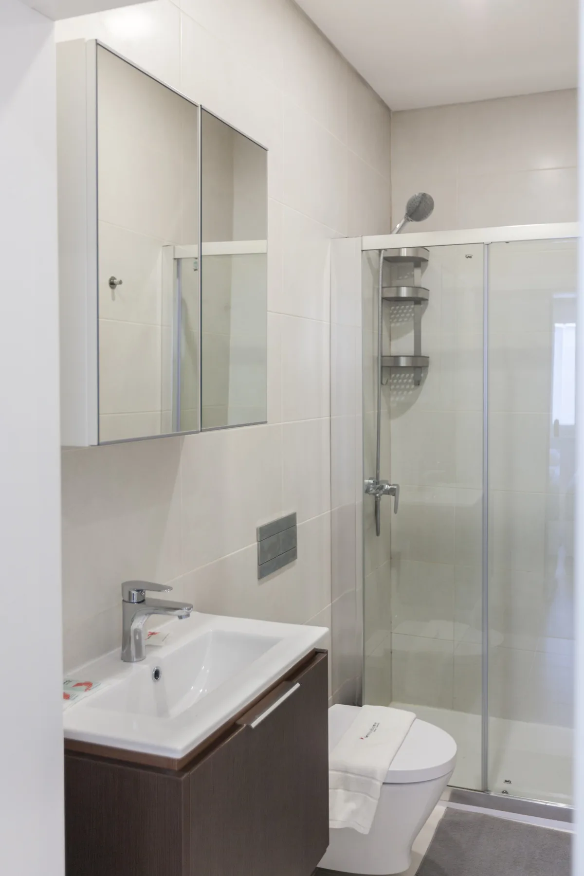 Un baño con lavabo, inodoro y ducha de vidrio.