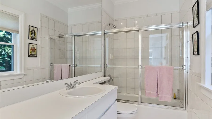 Un baño con azulejos, un lavabo amplio, bañera y ducha de vidrio.